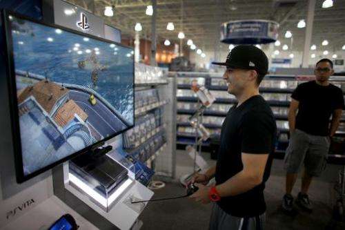 A customer tries out the new Sony PS4 at a Best Buy store after they went on sale at midnight on November 15, 2013 in Pembroke P