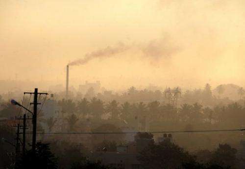 A factory chimney emits smoke as haze covers Bangalore, southern India on December 11, 2009