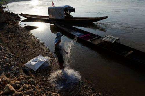 A fisherman stands on the bank of the Mekong river as he checks his net, in Wiang Kaen, on May 29, 2013