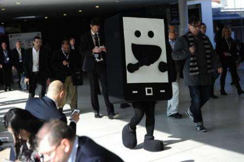 A hostess wearing a mobile phone costume walks at the 2013 Mobile World Congress in Barcelona on February 26, 2013