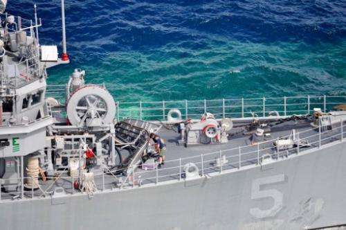 A January 23, 2013 US Navy handout shows a salvage assessment team working aboard USS Guardian