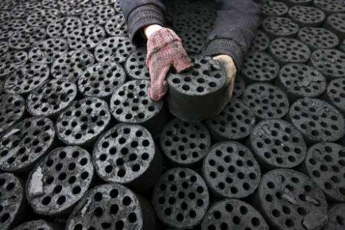 A labourer is seen handling coal briquettes in Huaibei, central China's Anhui province, on January 30, 2013