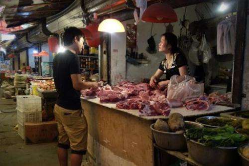 A man browses meat at a shop selling pork in Beijing on June 1, 2013