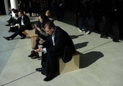 A man checks a mobile phone at the 2013 Mobile World Congress in Barcelona on February 26, 2013