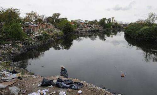 A man of the Villa 21-24 shantytown rummages through garbage on the shore of the Riachuelo in Buenos Aires on October 4, 2011