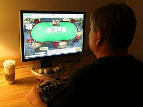 A man plays poker on an Internet gaming site from his home in Manassas, Virginia on October 2, 2006