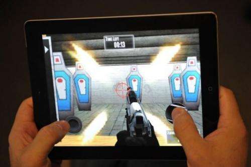 A man plays the National Rifle Association (NRA) iPhone/iPad app, "NRA: Practice Range" on January 15, 2012