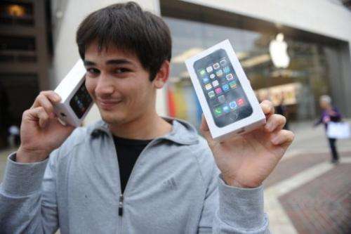A man poses with his two new Apple iPhone 5S in Glendale, California, September 20, 2013