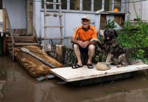 A man sits with his dog on his porch in Krasnaya Rechka near Khabarovsk in Russia's Amur region on August 22, 2013.