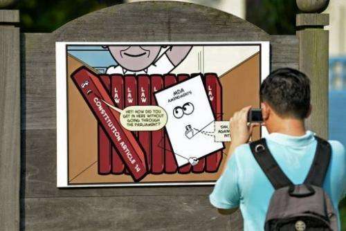 A man takes a picture of a placard during a rally at Speakers' Corner in Singapore, on June 8, 2013