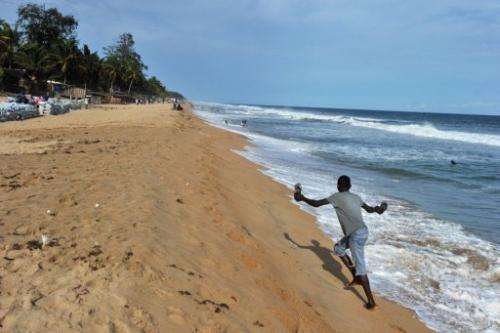 A man walks on the beach of Grand-Bassam, a town 40 km east of Abidjan threatened by coastal erosion, on May 17, 2012