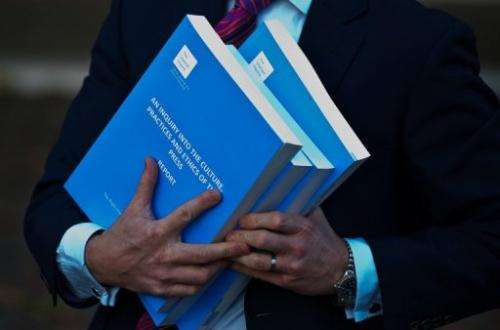A member of the press holds copies of the Leveson Inquiry into press standards in London, on November 29, 2012