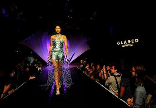 A model struts down a runway wearing a dress made from plastic rings at the Glazed Conference in San Francisco, California on Se