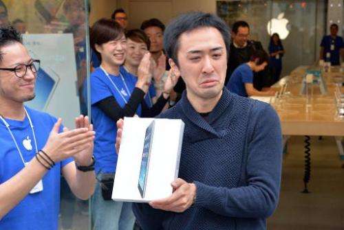 An Apple store's first customer of the day shows off his iPad Air tablet in Tokyo on November 1, 2013