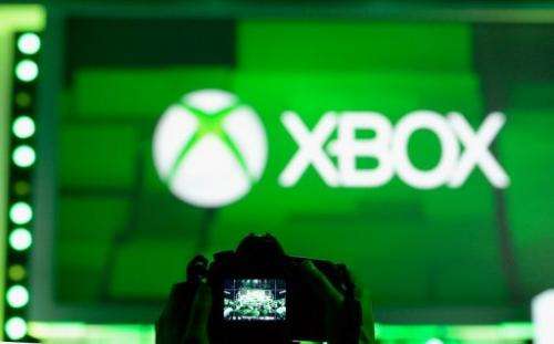 An attendee takes a photo of the Xbox logo during a Microsoft Xbox news conference on June 10, 2013, in Los Angeles
