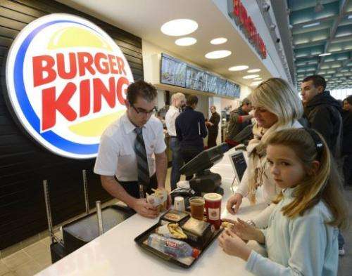 An employee serves customers at the Burger King fast food restaurant in Marseille's airport on December 22, 2012