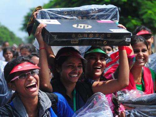 An Indian student holds a Hewlett-Packard laptop given to her by Indian chief minister of Utar Pradesh, Akhilesh Yadav at a cere