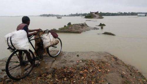 An Indian villager looks across a road that was washed away by floods at Burgaon Patekibori village, on October 9, 2012