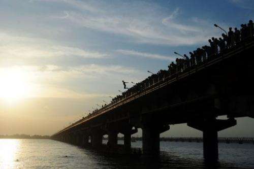 An Indian youth jumps from the from Shashtri bridge into the River Ganges in Allahabad on August 1, 2013