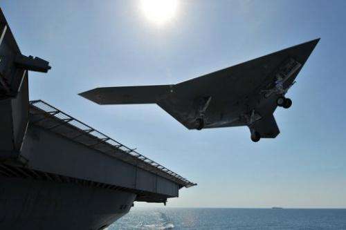 An X-47B unmanned combat air system demonstrator conducts a landing on May 17, 2013 on a deck in the Atlantic Ocean