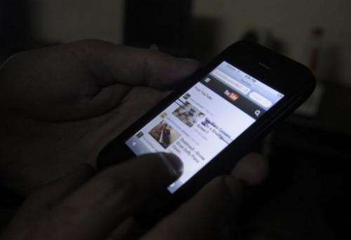 A Pakistani cell phone user browses YouTube on his mobile phone in Quetta on December 29, 2012