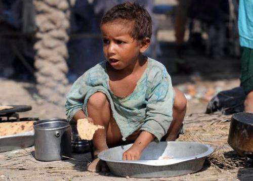 A Pakistani child displaced by flood eats at at a relief camp in Sukkur on August 18, 2010