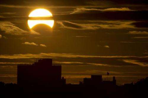 A partial Solar eclipse is seen just after sunrise over the Queens borough of New York across the East River on November 3, 2013