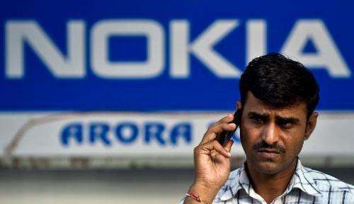 A passer-by talks on his mobile phone outside a Nokia store in New Delhi on October 1, 2013