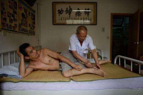 A patient receives a bee sting administered by a doctor of traditional Chinese medicine on August 2, 2013