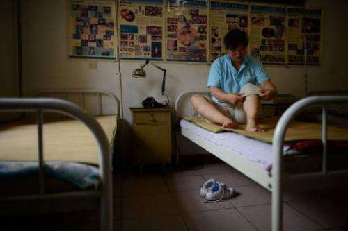 A patient rests after receiving bee stings administered by a doctor of traditional Chinese medicine on August 2, 2013