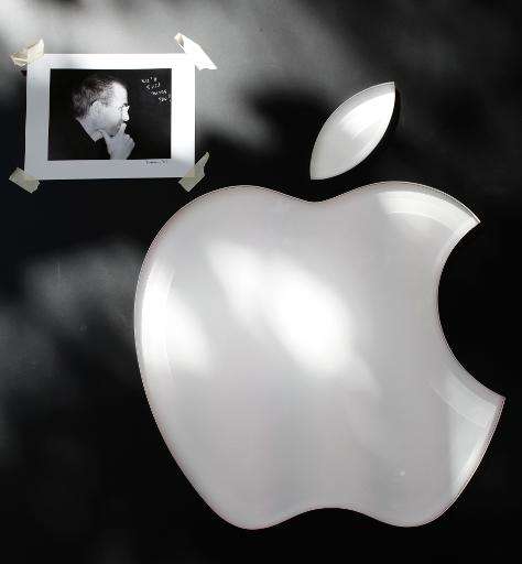 A picture of the late Apple co-founder Steve Jobs is displayed next to the company logo at the Apple store in Palo Alto on Octob