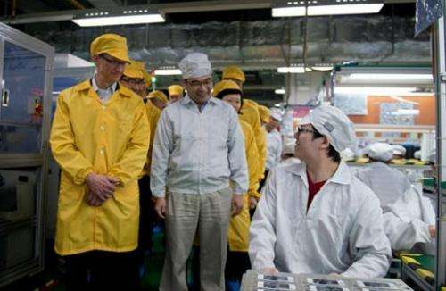 Apple chief executive, Tim Cook (L), visits the iPhone production line in Zhengzhou, on March 28, 2012