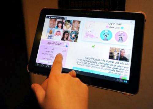 A Saudi woman uses a tablet computer to visit a website offering a matchmaking service for people hoping to get married