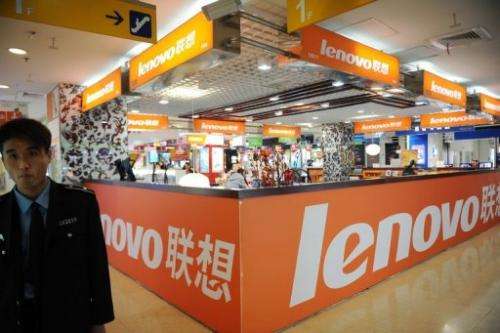 A security guard walks past a Lenovo shop in a computer mall in Beijing on November 3, 2011