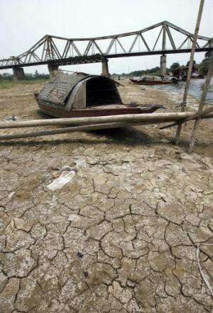 A small boat lies on the bed of the Red River as it has been hit by drought near Hanoi, on April 19, 2007