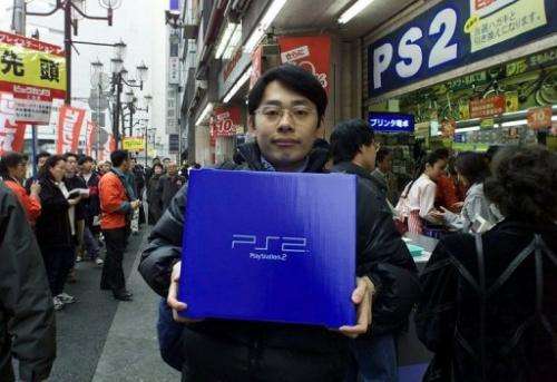 A student holds his newly bought Sony's PlayStation 2 video game console, in Tokyo, on March 4, 2000