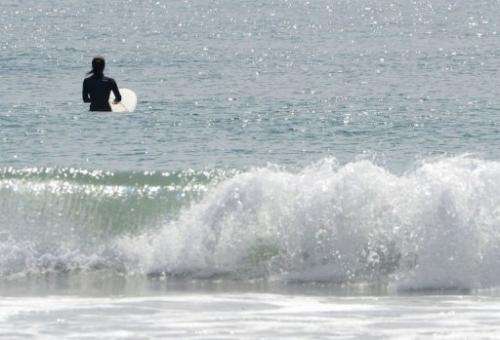A surfer waits for waves on Toyoma Beach, some 50 kilometres south of the Fukushima nuclear power plant, August 24, 2013