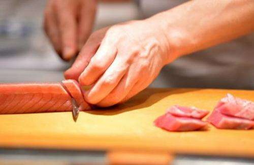 A sushi chef slices up tuna at a restaurant in Tokyo on July 16, 2013