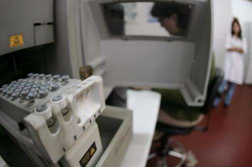 A technician prepares vials for DNA testing at a laboratory in Madrid on November 20, 2007