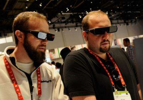 Attendees of a technology convention wear 3D glasses in the a booth during on January 11, 2012 in Las Vegas, Nevada