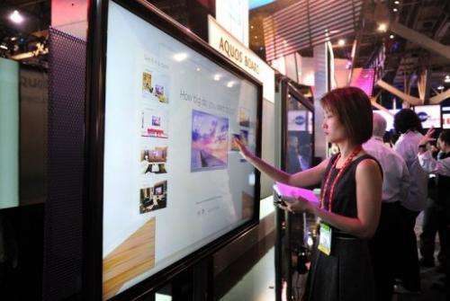 A visitor checks out a Sharp's touch screen TV set at an electronics show in Las Vegas, Nevada, on January 10, 2012