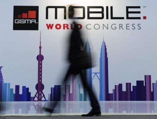 A visitor walks past a board for the Mobile World Congress, in Barcelona, on February 25, 2013