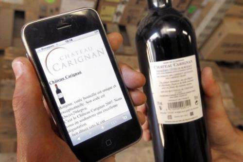 A wine-drinker checks the tracking of a wine bottle on his smart phone, western Frane, June 6, 2010