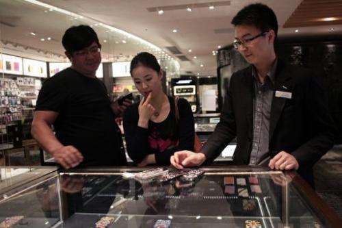 A woman inspects custom-built iPhone cases in Hong Kong on April 23, 2013.