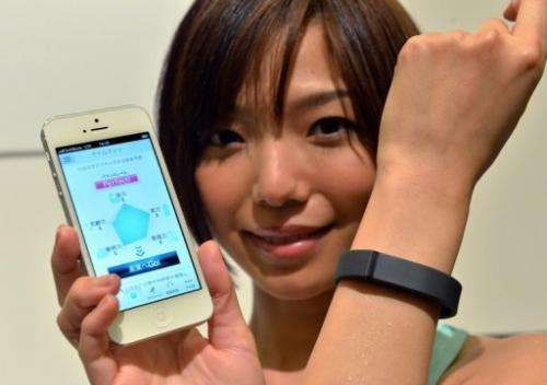 A woman models a Fitbit Flex wristband in Tokyo on May 7, 2013