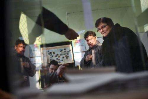 A woman receives a ballot at a polling station during the national referendum in the town of Belene on January 27, 2013