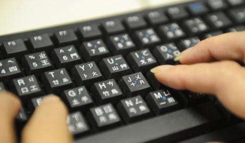 A woman uses a keyboard with keys illustrating both Roman letters and parts of Chinese charactures on August 27, 2010