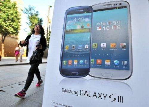 A woman walks past an advertisement for the Samsung Galaxy S3 smartphone in Seoul on August 27, 2012