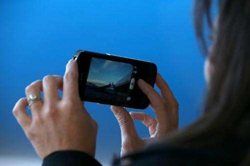 A woman watches a video on an iPhone as her plane lands at Denver International Airport in Denver, Colorado on October 23, 2012