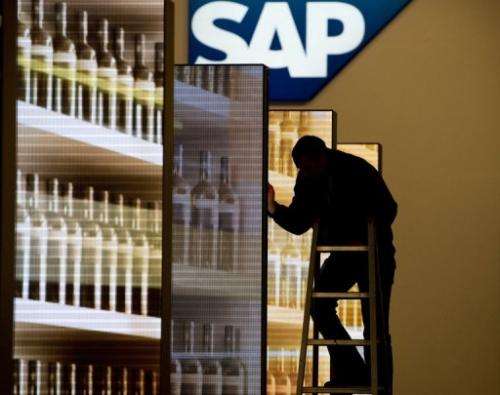 A worker adjusts screens at the stand of German software company SAP, prior to an IT fair in Hanover, on March 5, 2012